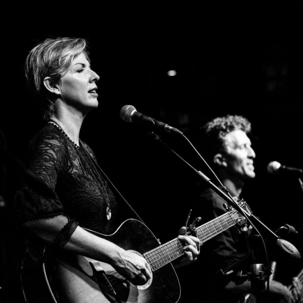 Coffee Snobs performing on acoustic guitar at festival