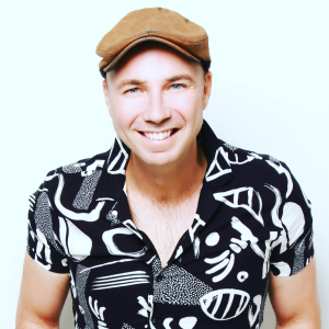 Jakkie Louw smiling while performing upbeat Afrikaans rock on stage